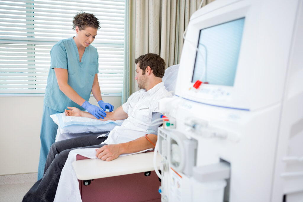 female nurse injecting patient for renal dialysis treatment